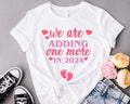 Valentine Pregnancy Announcement Shirt, We're adding one More in 2024 T-Shirt, Pregnancy Reveal Tee, New Mother Gift...